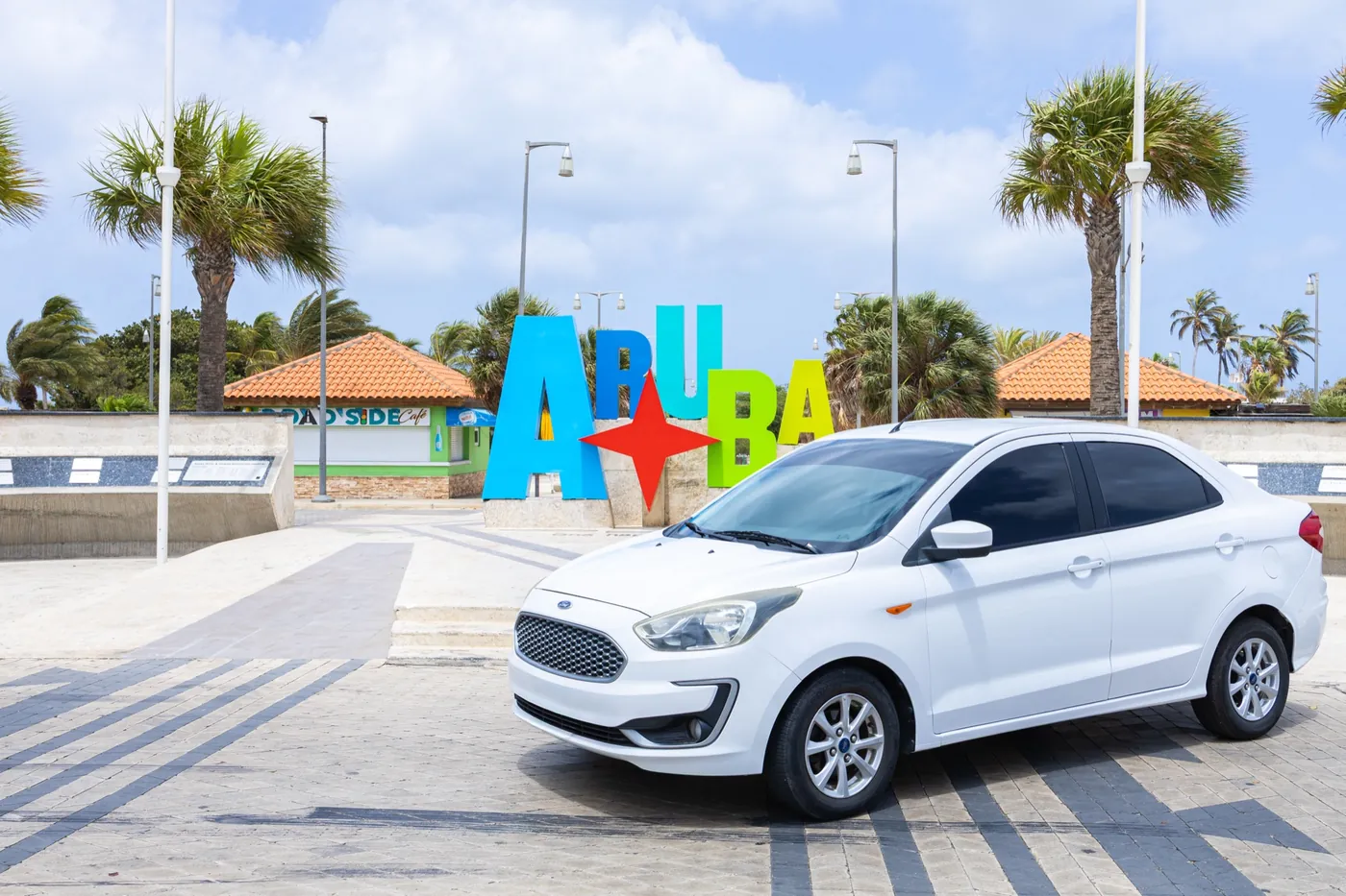 A rental car in front of the colourful Aruba sign